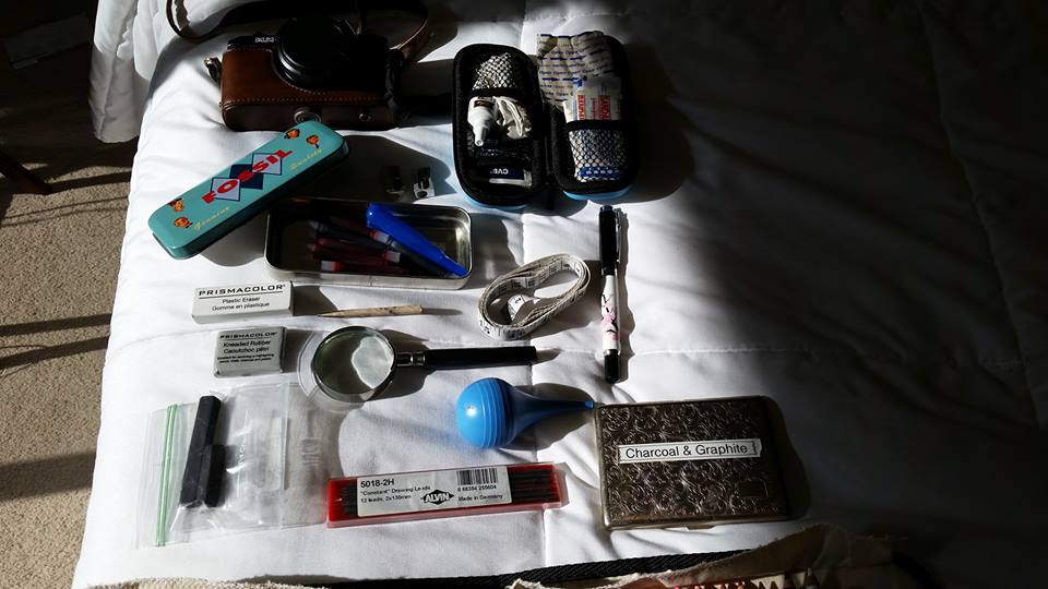 Camera, mini first aid kit, ink and pen supplies, sharpeners, fountain pen, measuring tape, smudge pencil, erasers, magnifying glass, charcoal, drafting pencil lead, bulb syringe for cleaning out pens, charcoal and graphite.